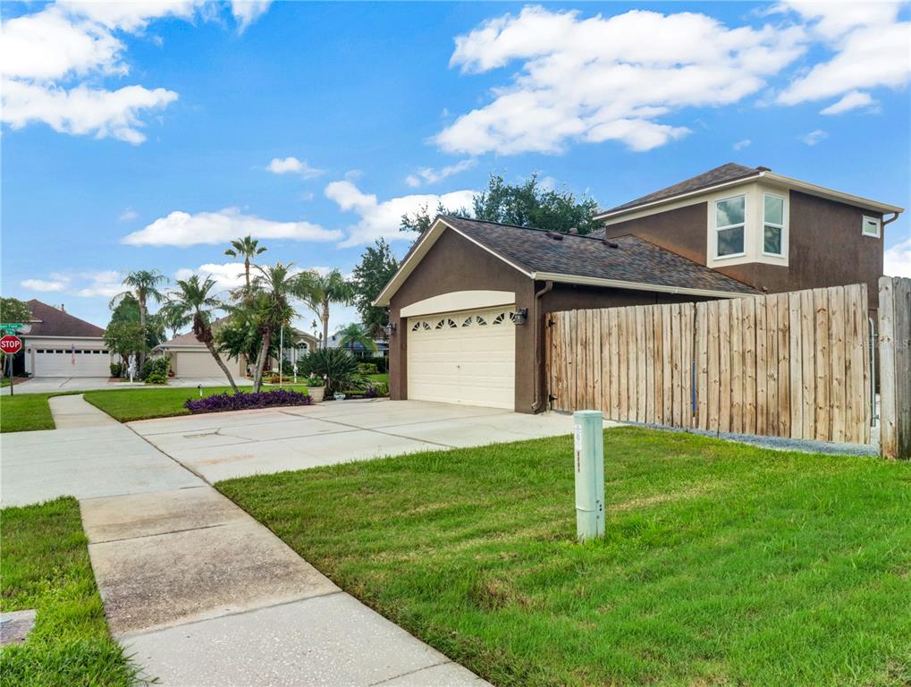 A two-story house with a brown exterior, a two-car garage, and a wooden privacy fence — 2002 RAIN DANCE PLACE, BRANDON, FL