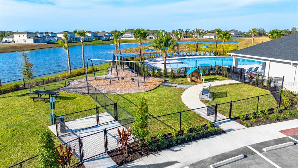 An outdoor community area features a playground, fenced dog park, swimming pool, and lake view — 860 STEEL DRIVE, APOLLO BEACH, FL
