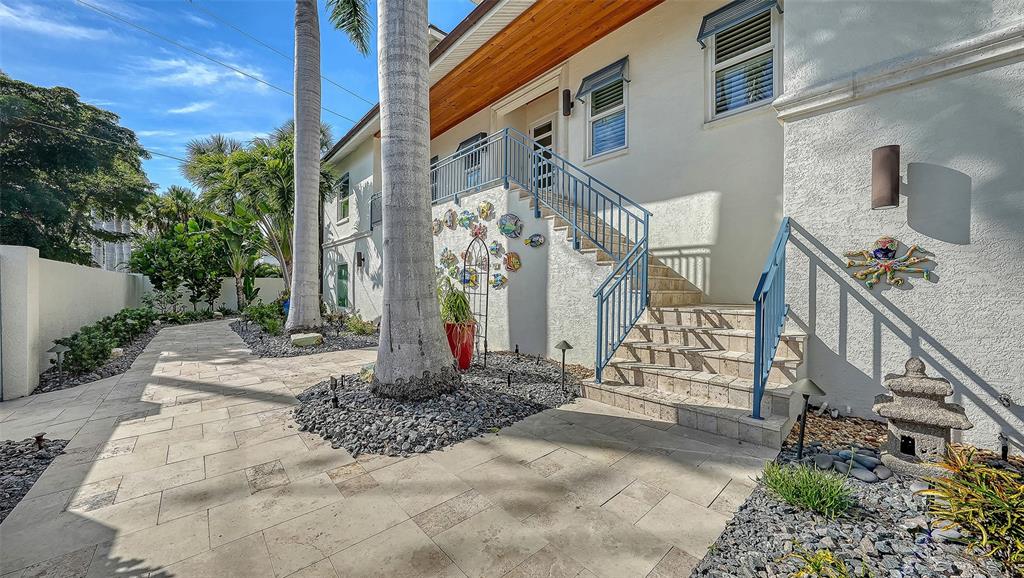 A two-story house with a gated entrance, palm trees, and decorative wall art — 345 MADISON DRIVE, SARASOTA, FL