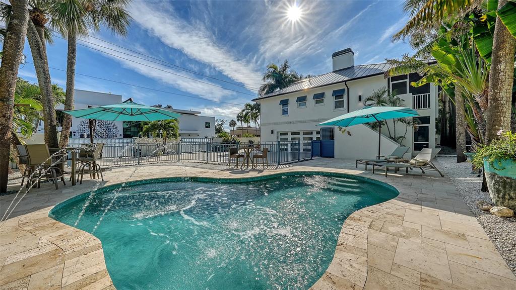 An exterior view shows a stone staircase with blue railings leading to a house entrance — 345 MADISON DRIVE, SARASOTA, FL