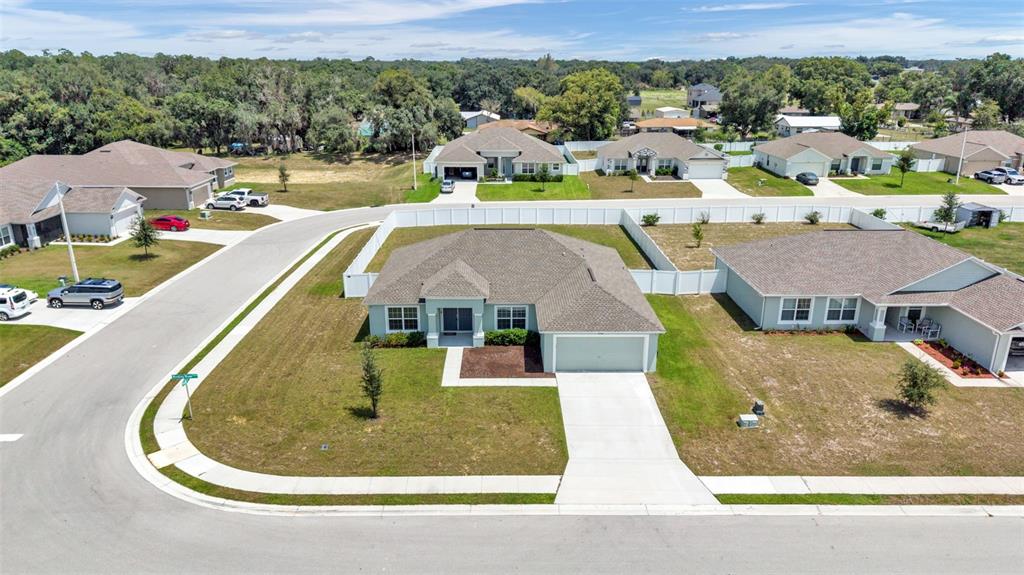 An aerial view shows a suburban neighborhood with several single-story houses and paved streets — 2048 WINDING RIVER COVE, BARTOW, FL