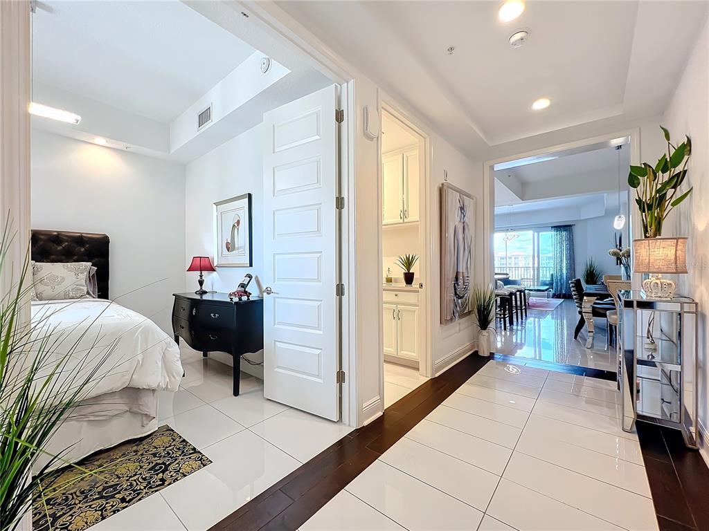 A hallway with white tile floors leads to a bedroom, a bathroom, and a living area — 10530 BOARDWALK LOOP UNIT 304, BRADENTON, FL