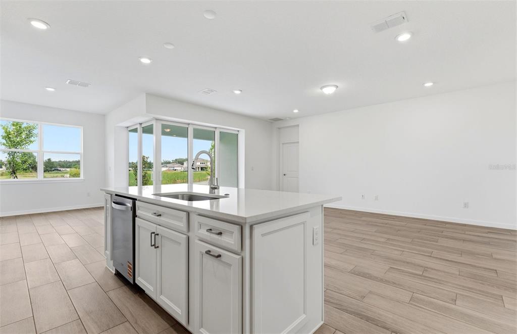 A kitchen island with a sink and dishwasher sits in a room with light flooring — 37821 CLINCH CIRCLE, ZEPHYRHILLS, FL