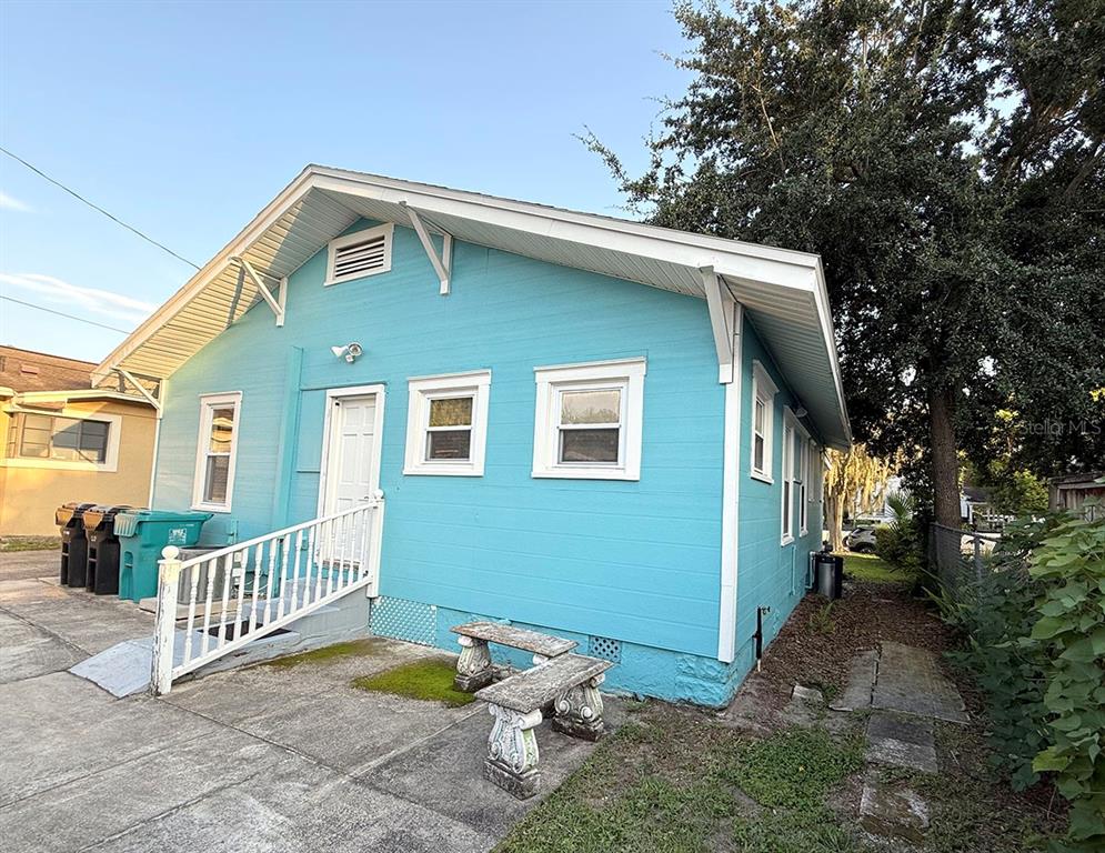 A bright blue house with a white door, ramp, and two stone benches outside — 1407 E RIDGEWOOD STREET, ORLANDO, FL