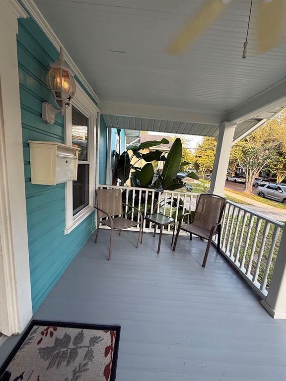 A covered porch features teal siding, a white mailbox, two chairs, and a small table — 1407 E RIDGEWOOD STREET, ORLANDO, FL
