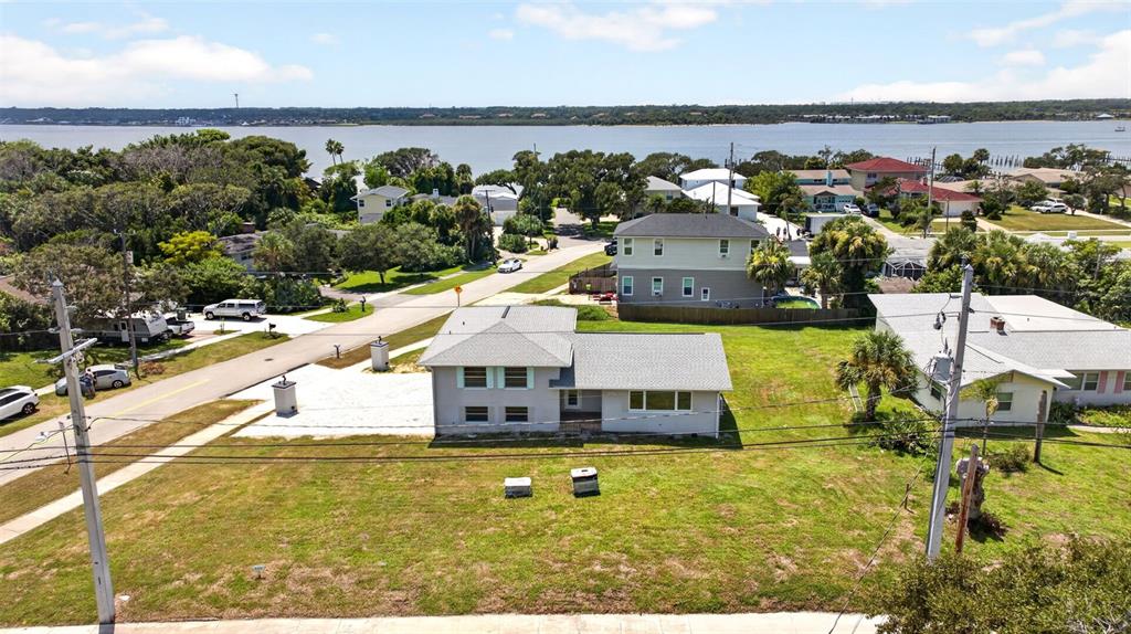 An aerial view shows a single-story house with a gray roof and a large lawn — 2314 S PENINSULA DRIVE, DAYTONA BEACH, FL