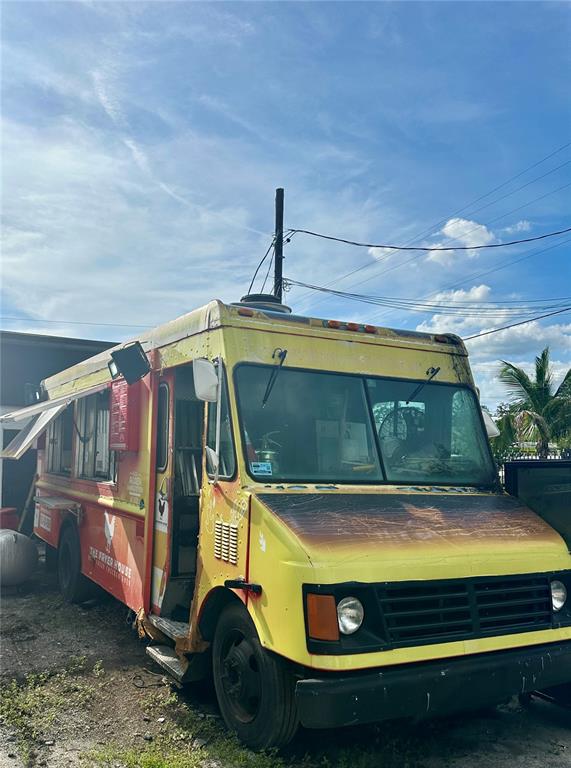 A yellow and red food truck is parked on a dirt lot under a blue sky — 6617 N NEBRASKA AVENUE, TAMPA, FL