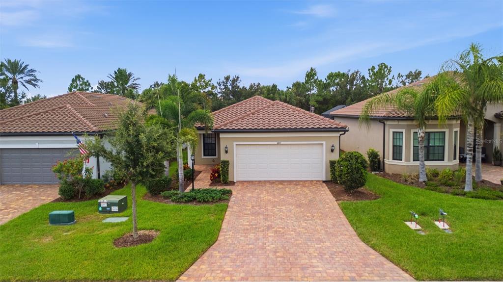 A single-story house with a tiled roof, a paver driveway, and a two-car garage — 6713 ALSTEAD CIRCLE, BRADENTON, FL