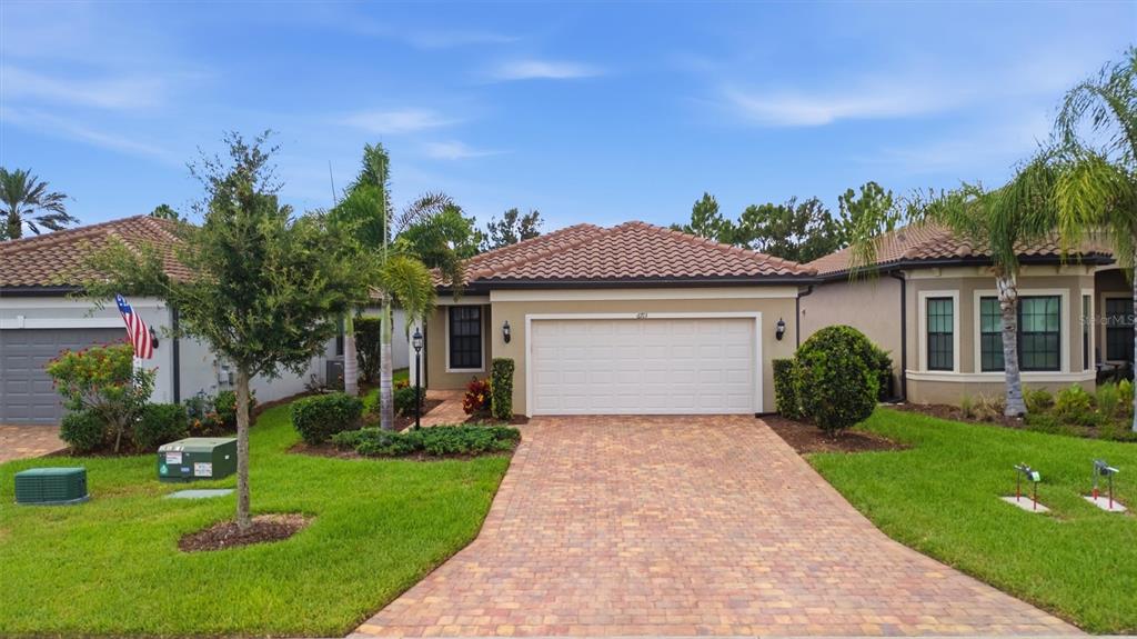A single-story house with a tiled roof, a two-car garage, and a paved driveway — 6713 ALSTEAD CIRCLE, BRADENTON, FL