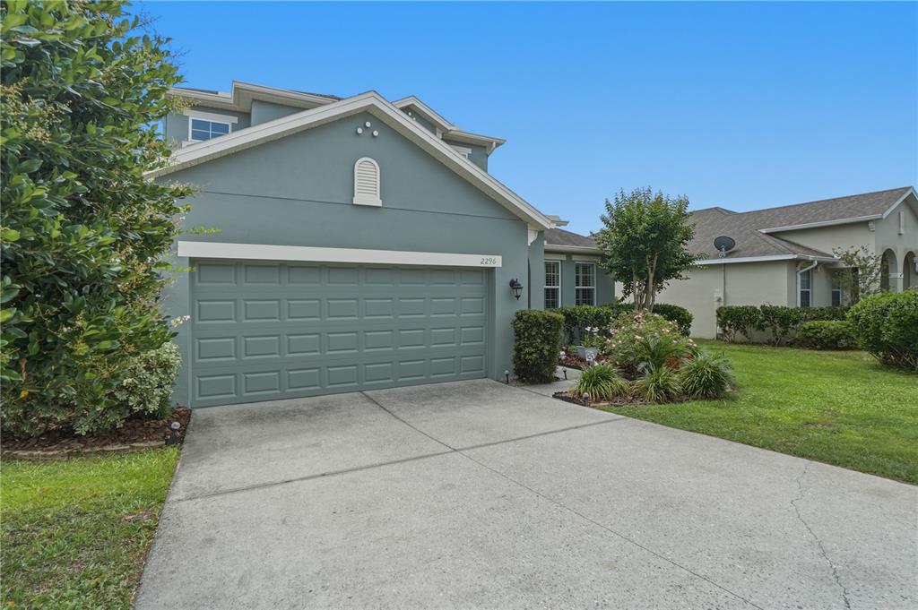 A two-story house with a blue-green exterior and a two-car garage — 2296 NATOMA BOULEVARD, MOUNT DORA, FL