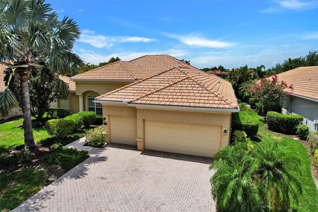 An aerial view of a tan house with a tiled roof and a paved driveway — 7910 RIVER PRESERVE DRIVE, BRADENTON, FL