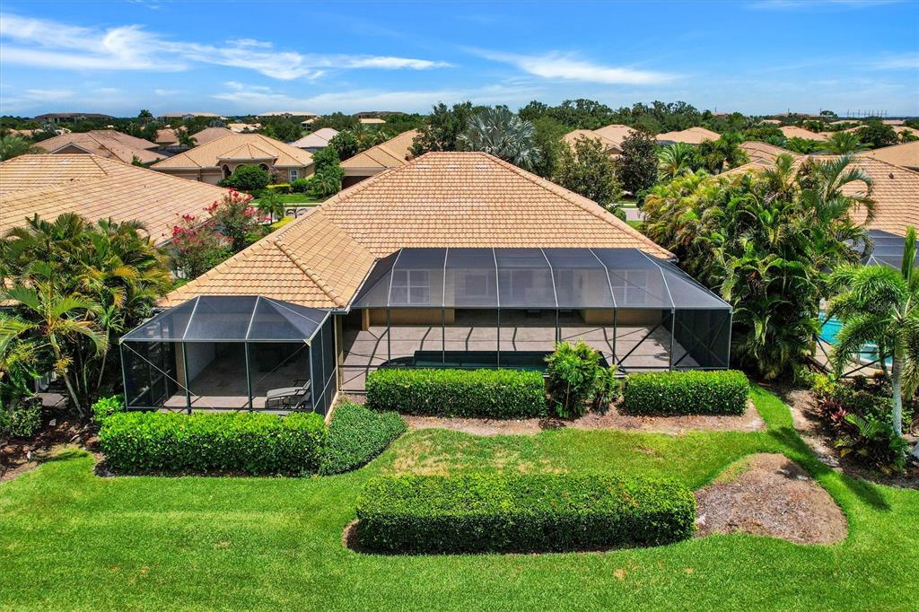 An aerial view of a house with a screened-in pool enclosure and a landscaped backyard — 7910 RIVER PRESERVE DRIVE, BRADENTON, FL