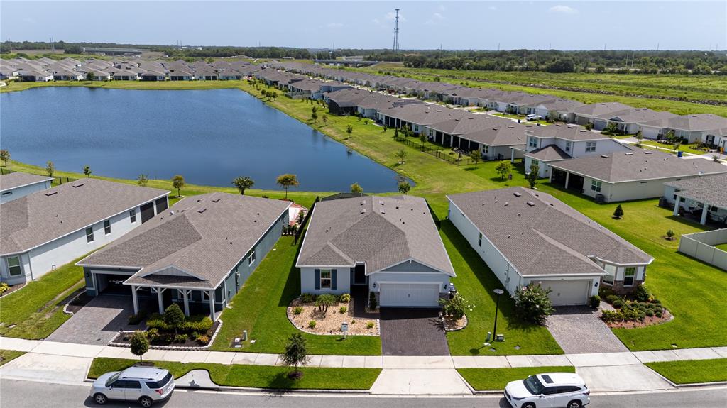 An aerial view shows a row of suburban houses with a lake in the background — 1994 SPRING SHOWER CIRCLE, KISSIMMEE, FL