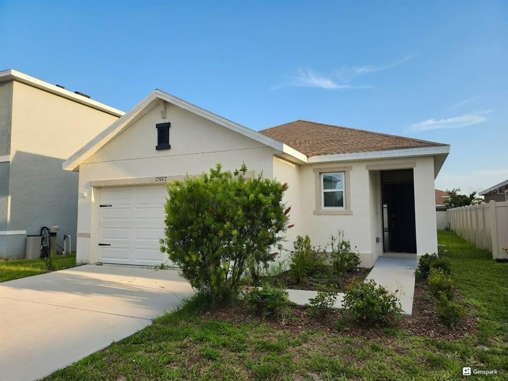 A single-story house with a white stucco exterior, a one-car garage, and a front walkway — 17007 BLISTER WING DRIVE, WIMAUMA, FL