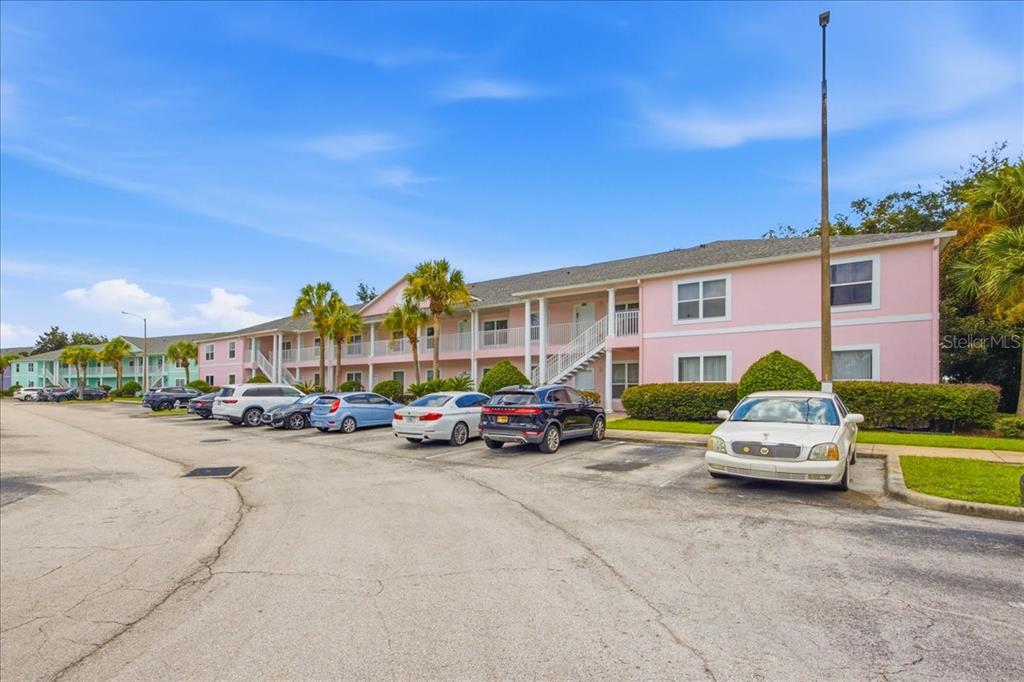 A pink multi-story apartment building with a parking lot in the foreground — 3157 SUN LAKE COURT UNIT A, KISSIMMEE, FL