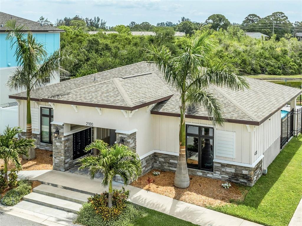 A single-story house with a stone-accented facade, palm trees, and a shingled roof — WHITNEY ROAD, CLEARWATER, FL