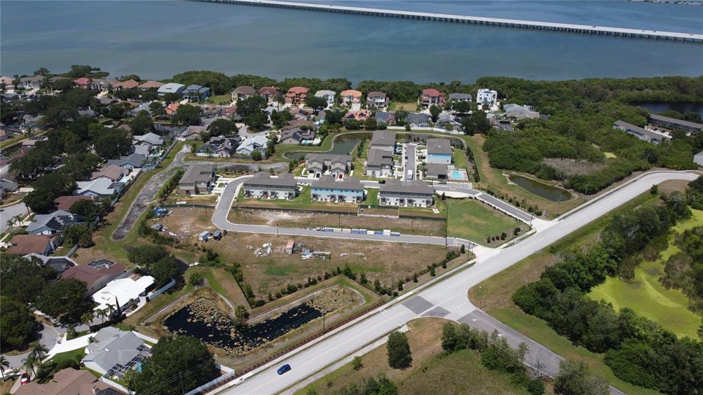 An aerial view shows a residential neighborhood under construction near a body of water — WHITNEY ROAD, CLEARWATER, FL