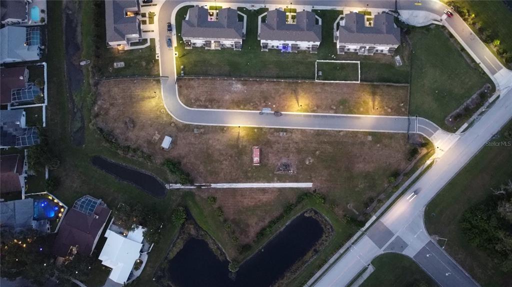 An aerial view shows a vacant residential lot surrounded by houses, roads, and small ponds — WHITNEY ROAD, CLEARWATER, FL
