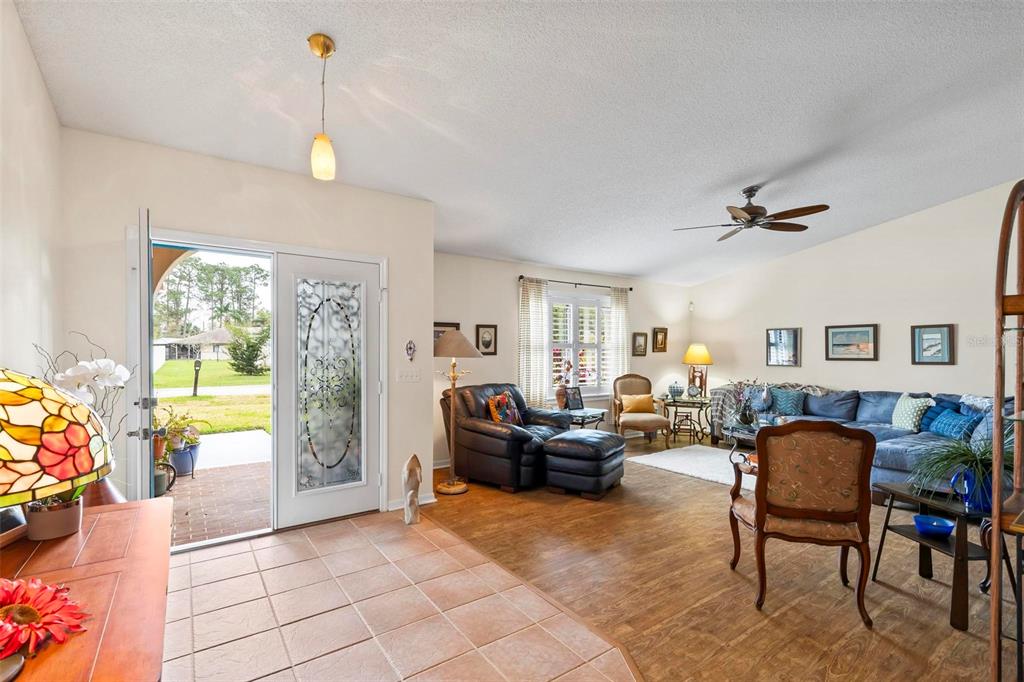 A living room features tile and wood flooring, a ceiling fan, and an open front door — 130 BAYSIDE DRIVE, PALM COAST, FL
