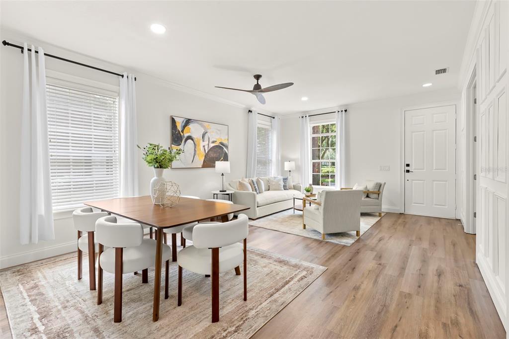 A bright open-concept living and dining area with wood-look flooring and white walls — 14743 CANOPY DRIVE, TAMPA, FL