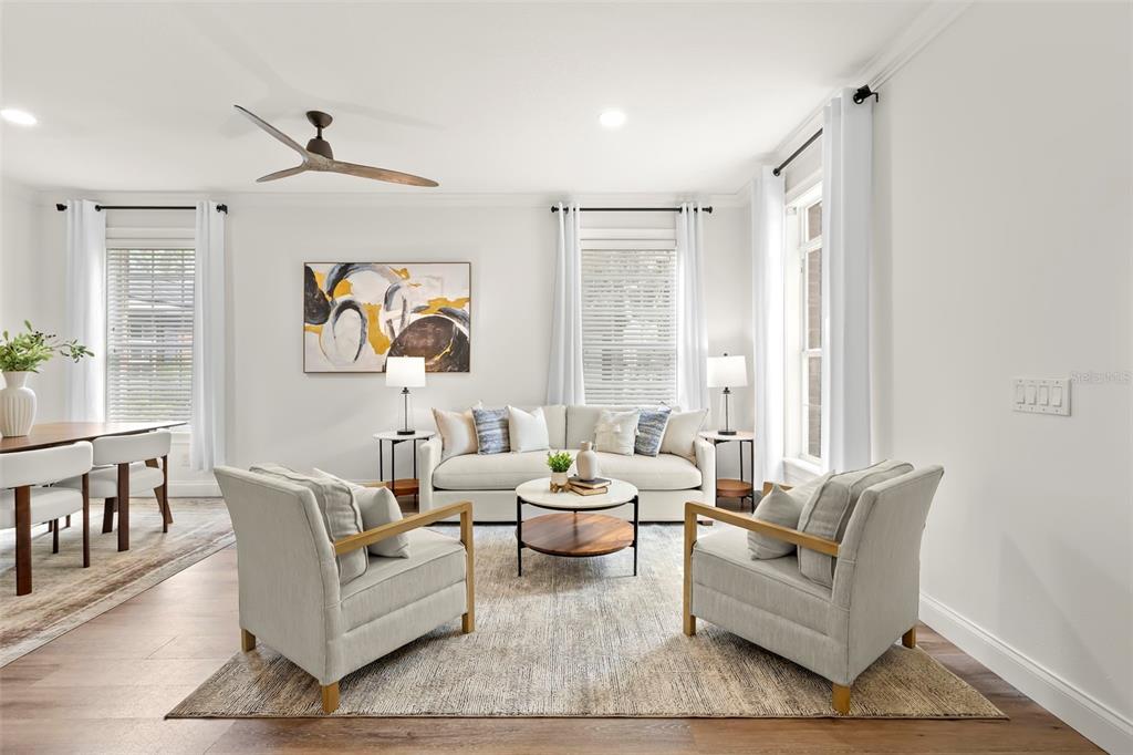 A bright living room features a white sofa, two armchairs, a coffee table, and hardwood floors — 14743 CANOPY DRIVE, TAMPA, FL