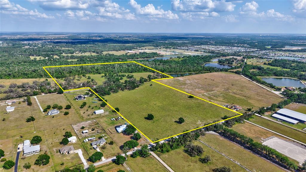 An aerial view shows a large, grassy plot of land outlined in yellow — 5900 SPENCER PARRISH ROAD, PARRISH, FL