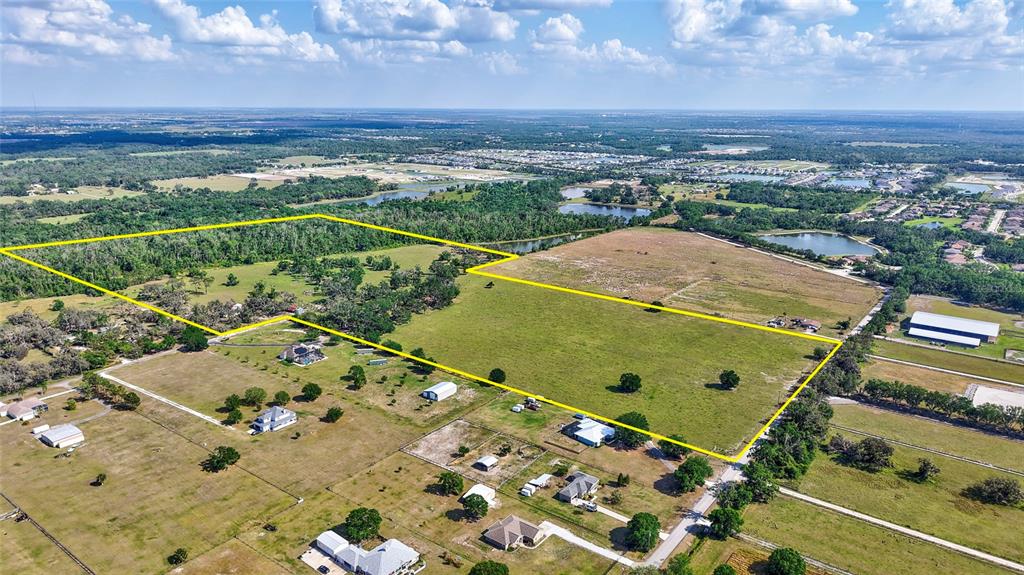 An aerial view shows a large, grassy plot of land outlined in yellow with scattered buildings — 5900 SPENCER PARRISH ROAD, PARRISH, FL