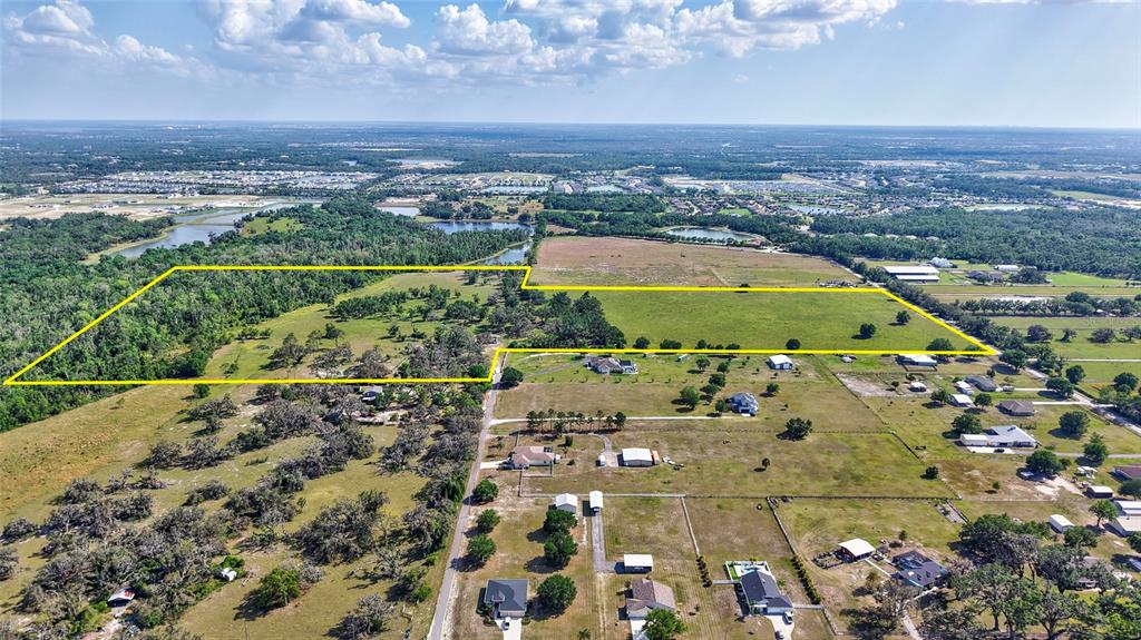An aerial view shows a large, rectangular parcel of land outlined in yellow — 5900 SPENCER PARRISH ROAD, PARRISH, FL