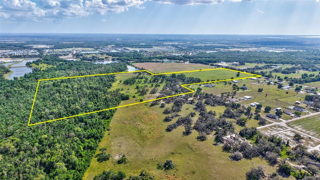 An aerial view shows a large, undeveloped plot of land outlined in yellow — 5900 SPENCER PARRISH ROAD, PARRISH, FL