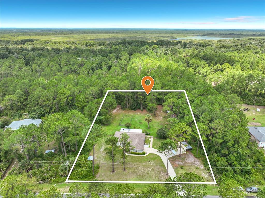 An aerial view shows a house on a large, wooded lot with a marked property boundary — 41821 ROYAL TRAILS ROAD, EUSTIS, FL
