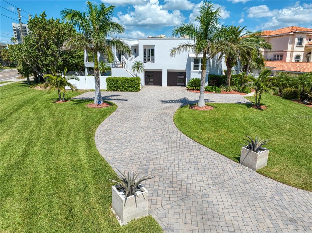 A two-story white house features a paved driveway, palm trees, and a manicured lawn — 101 HARRISON AVENUE, BELLEAIR BEACH, FL