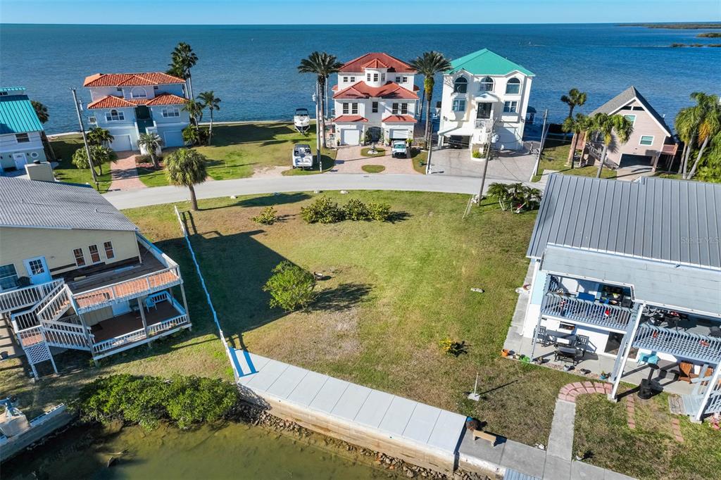 An aerial view shows a vacant waterfront lot situated between two houses near the ocean — 6424 DRIFTWOOD DRIVE, HUDSON, FL