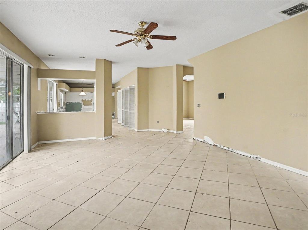 An empty room with beige tile flooring, tan walls, and a ceiling fan — 1268 FOXFORREST CIRCLE, APOPKA, FL