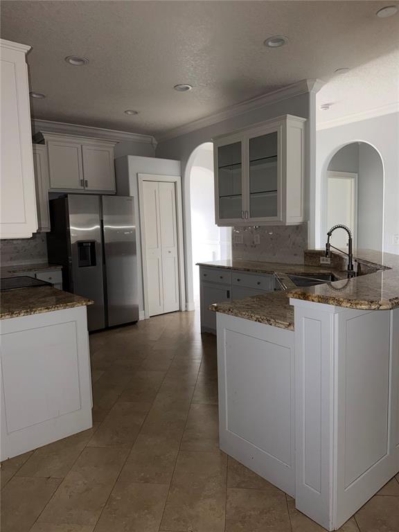 A kitchen features white cabinets, granite countertops, stainless steel appliances, and tile flooring — 3212 MERRICK AVENUE, ROCKLEDGE, FL