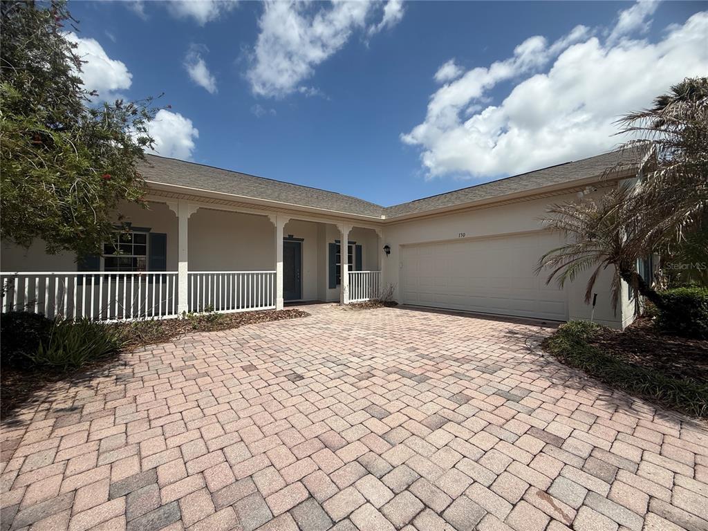 A single-story house with a paved driveway, a covered front porch, and a two-car garage — 130 PRIMA DRIVE, KISSIMMEE, FL