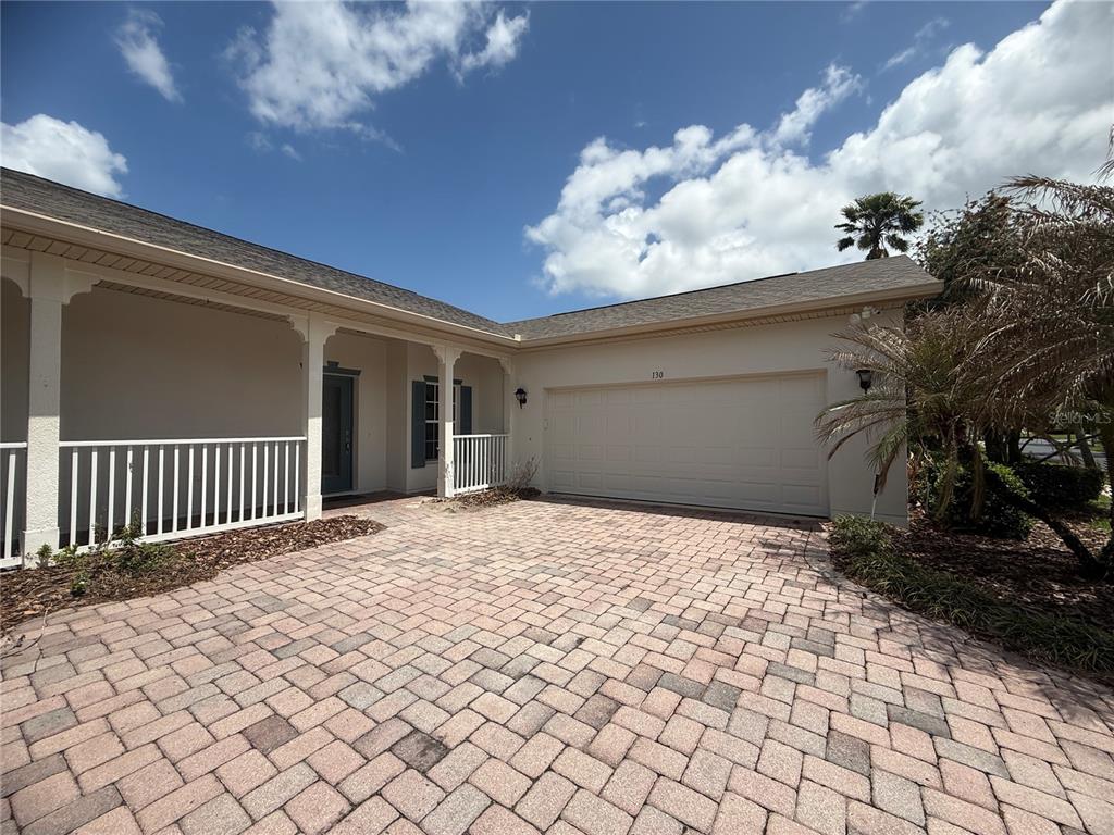 A single-story house with a paved driveway, two-car garage, and a covered front porch — 130 PRIMA DRIVE, KISSIMMEE, FL