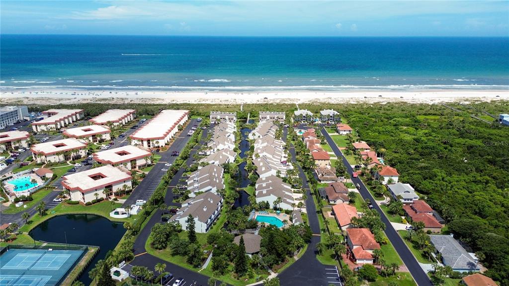 An aerial view shows a beachfront residential complex with multiple buildings, pools, and tennis courts — 890 A1A BEACH BOULEVARD UNIT 31, ST AUGUSTINE, FL