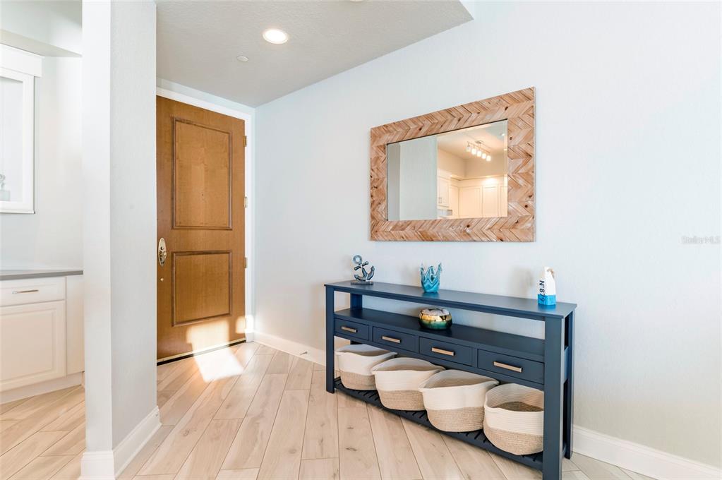 A dining area with a round table and patterned chairs overlooks a balcony and ocean — 1170 GULF BOULEVARD UNIT 2203, CLEARWATER BEACH, FL