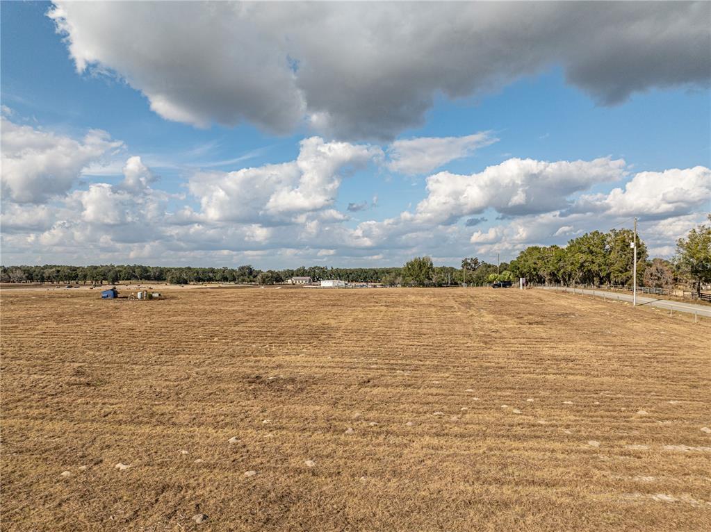 A vast, dry, open field under a cloudy sky with a road on the right — COUNTY ROAD 101, OXFORD, FL