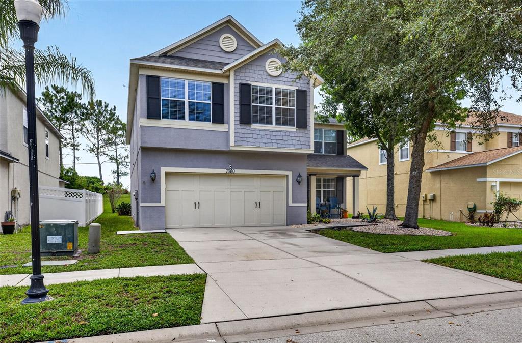A two-story suburban house with a two-car garage and a concrete driveway — 7360 BRIDGEVIEW, WESLEY CHAPEL, FL