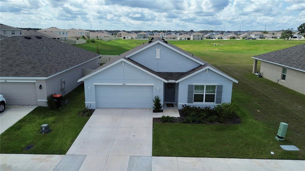 An aerial view shows a light blue single-story house with a two-car garage and lawn — 4728 SW 85TH PLACE, OCALA, FL