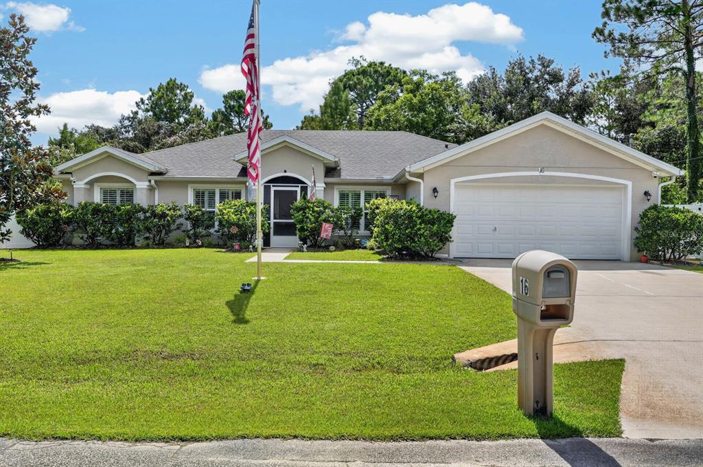 A single-story suburban house with a beige exterior, a two-car garage, and a front lawn — 16 SEVEN CHAMPIONS PATH N, PALM COAST, FL