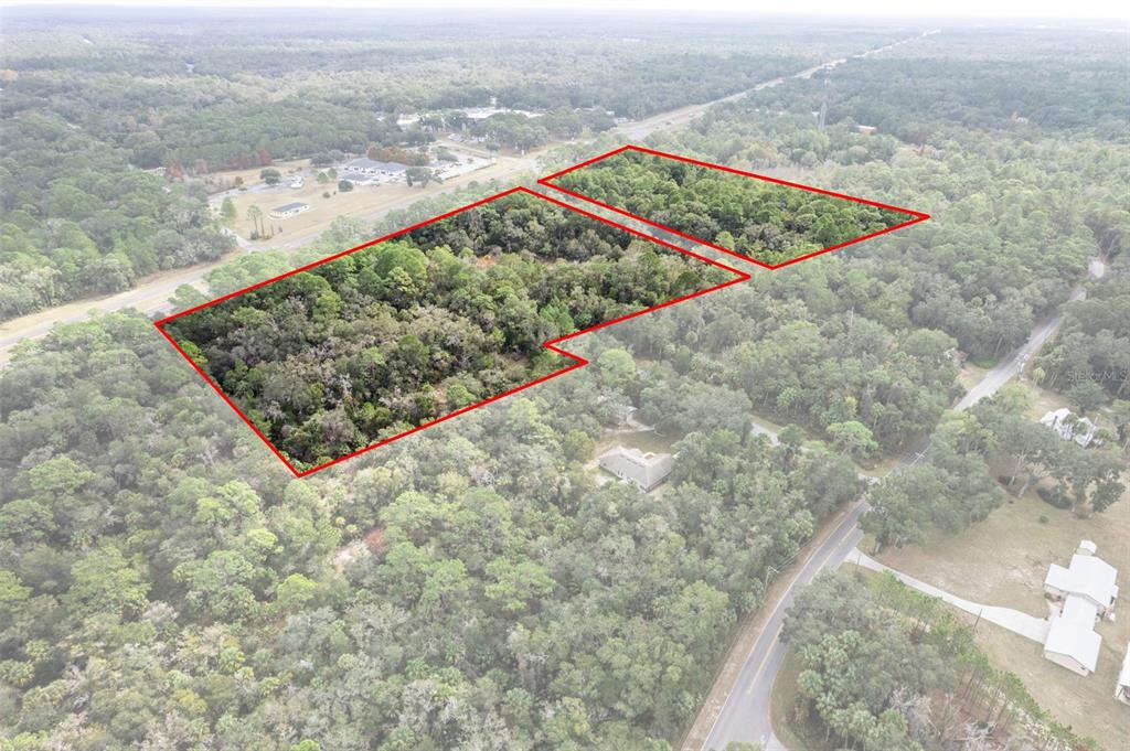 An aerial view shows two wooded parcels of land outlined in red near a road — 11621 W GARNET COURT, CRYSTAL RIVER, FL