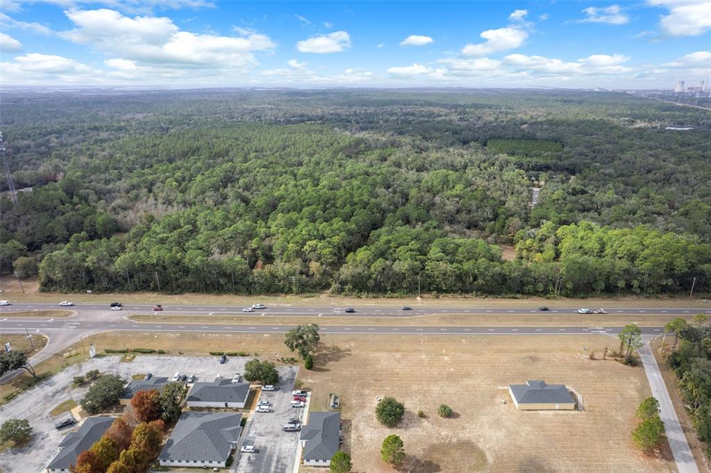 An aerial view shows a commercial parking lot and buildings adjacent to a divided highway — 11621 W GARNET COURT, CRYSTAL RIVER, FL