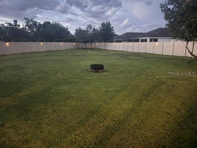 The exterior of a two-story house features a covered patio and a fenced backyard — 3504 BLITHE COURT, ST CLOUD, FL