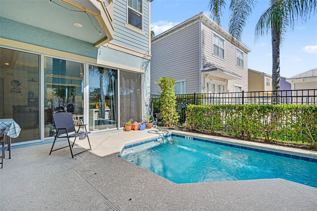 A sidewalk runs past a manicured hedge and two multi-story houses under a blue sky — 1432 REUNION BOULEVARD, REUNION, FL