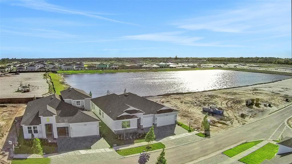 An aerial view shows two newly constructed houses next to a large retention pond — 5420 NW CAMBERLY COURT, PORT ST LUCIE, FL