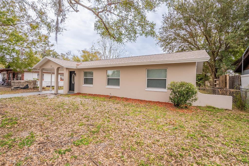 A single-story house with a beige exterior, a covered entryway, and a front yard — 1335 LESCOT LANE, ORLANDO, FL