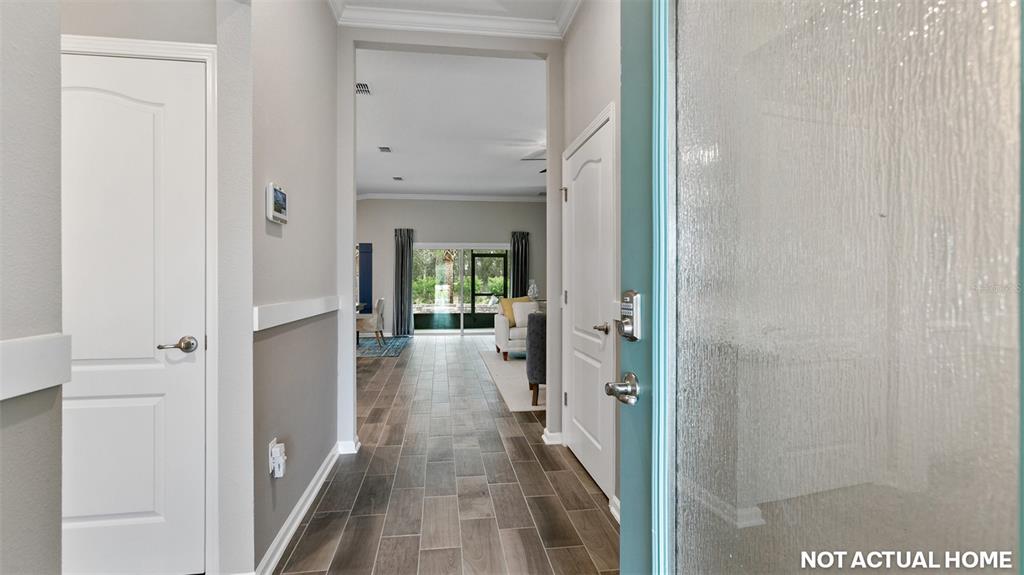 This is a rendering of a home entryway with tile flooring and two white doors — 59 HARDWOOD TRAIL, PALM COAST, FL