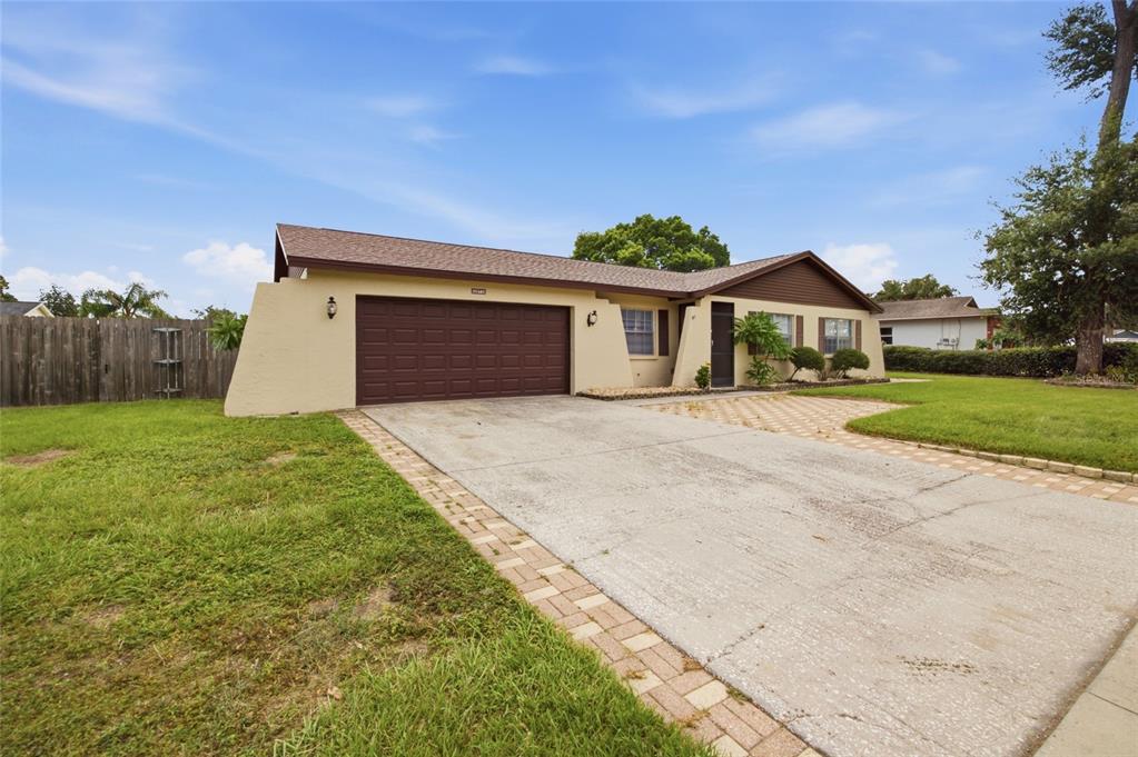 A single-story house with a brown garage door, tan stucco walls, and a concrete driveway — 2971 FOREST CIRCLE, SEFFNER, FL